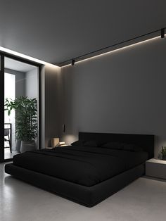 a large bed sitting in the middle of a bedroom next to a plant on top of a table