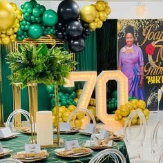 the table is set up with balloons, plates and napkins for an 70th birthday party