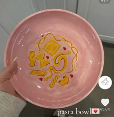 a person holding a pink bowl with yellow designs on it