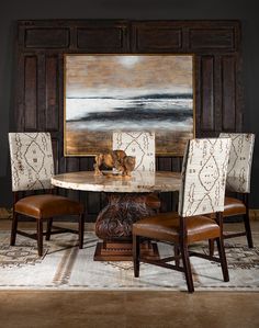 a dining room table with four chairs and a large painting on the wall behind it