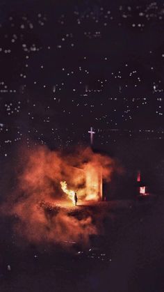 a person standing in front of a church on fire