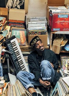 a man sitting on the ground surrounded by records