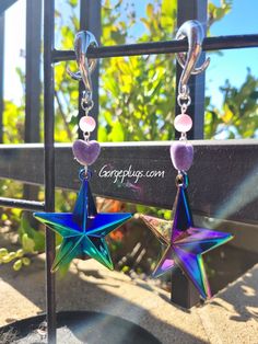 two star shaped earrings hanging from a metal rack