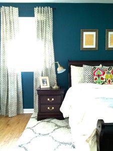 a bedroom with blue walls and white bedding