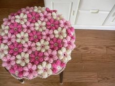 a pink and white crocheted table top on a wooden floor next to a door