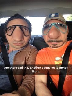 two men sitting in the back seat of a car, one with glasses on his head