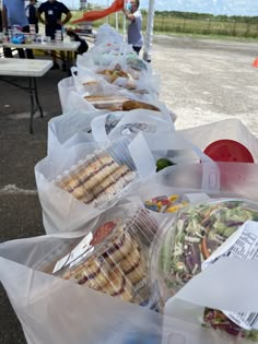 several plastic bags filled with food sitting on top of a table next to each other