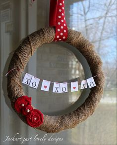 a burlock wreath hanging on the front door with valentine's day decorations