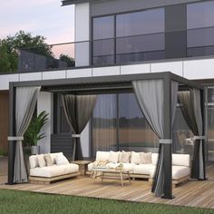 an outdoor living area with couches and curtains