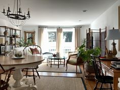 a living room filled with lots of furniture and a dining table in front of a window