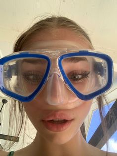 a woman wearing goggles and snorkels is making a funny face with her nose