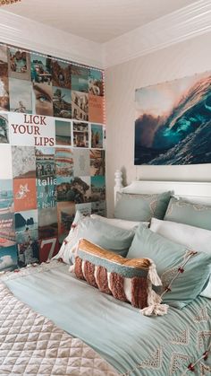 a bed with blue sheets and pillows in a bedroom next to a painting on the wall