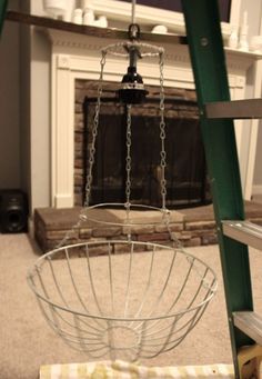 a large metal basket sitting on top of a wooden floor next to a fire place