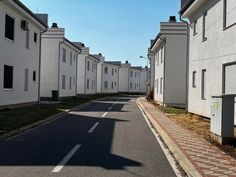 an empty street lined with white houses