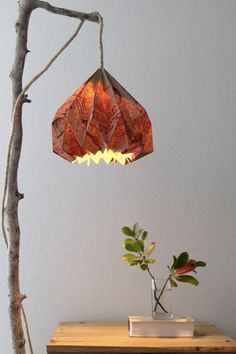 a lamp that is on top of a table next to a potted plant in a vase