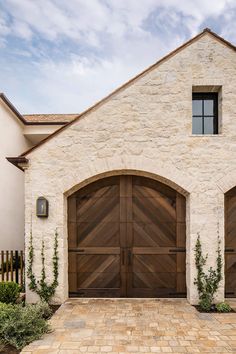 a large brick house with two wooden doors