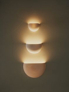 three light fixtures on the wall in a room