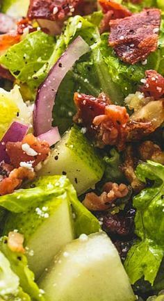 a salad with bacon, lettuce and other toppings on it is ready to be eaten