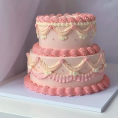 a three tiered cake with pink icing and ruffles on it's sides