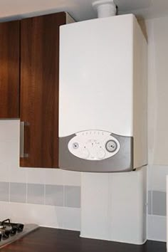 a kitchen with a stove top oven sitting next to a white refrigerator freezer mounted on the side of a wall