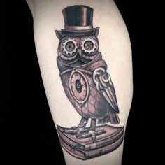 an owl with a top hat and eye glasses on it's head sitting on a book