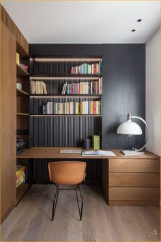 a room with a desk, bookshelf and lamp on it's side