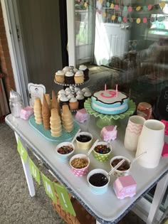 a table topped with desserts and cupcakes on top of it's sides