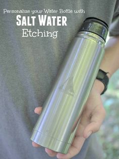 a person holding a water bottle with the words salt water etching on it