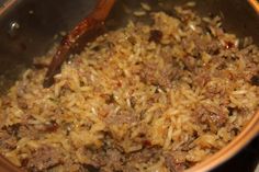 a pot filled with rice and meat on top of a stove