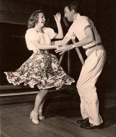 an old black and white photo of two people dancing