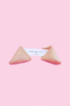 two triangular shaped objects on a pink background