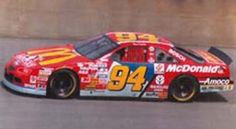 a red and yellow race car driving down a track with the number 94 mcdonald's on it