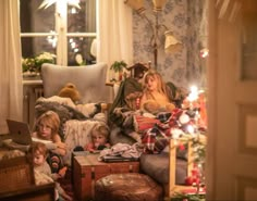 a group of people sitting on top of a couch in front of a christmas tree