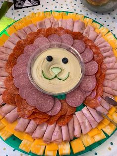 a platter with meats and cheese in the shape of a lion