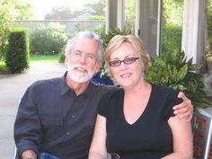 a man and woman sitting at a table outside