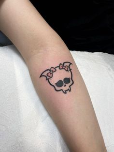 a person with a skull and bow tattoo on their arm