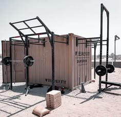 an outhouse made from shipping containers in the sand with bars attached to it's sides