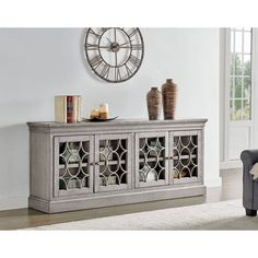 a living room scene with focus on the sideboard and clock in the wall behind it