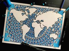 a blue and white world map is on a piece of paper next to some markers