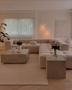 a living room filled with lots of furniture and flowers in vases on top of tables