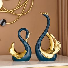 two blue and gold swan figurines sitting on a table