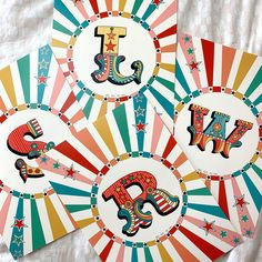 four circus themed paper plates with the letters j and i on them, all decorated in different colors