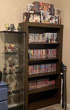 a book shelf filled with lots of comics and figurines on top of it