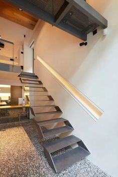 a set of stairs leading up to the second floor in a modern home with white walls and stone floors