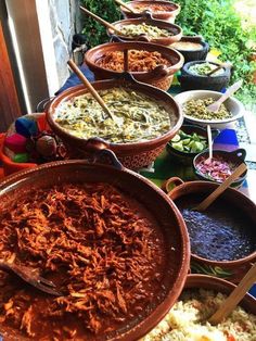 a table filled with lots of different types of food on top of plates and serving utensils