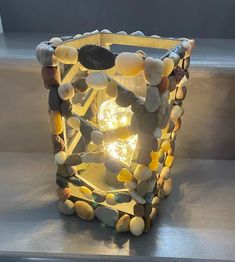 a light that is sitting on some kind of metal table top with rocks and pebbles around it