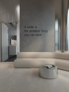 a white couch sitting in front of a wall with a quote on it's side