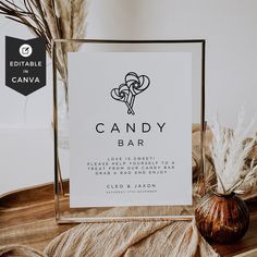 a candy bar sign sitting on top of a table next to a vase with dry grass