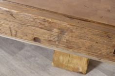 a wooden bench sitting on top of a hard wood floor next to a metal pole