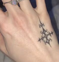 a woman's hand with a tattoo on it and a ring in the middle